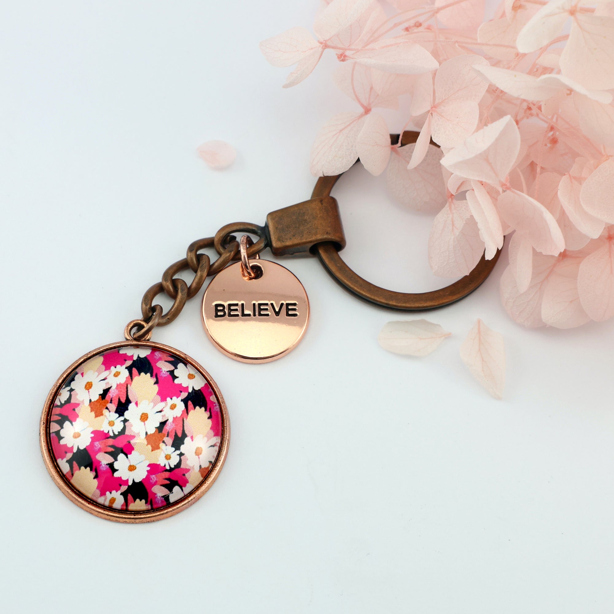 Circle pendant keychain in vintage copper with 'believe' charm, bright pink floral print. Fundraiser for the national breast cancer foundation.