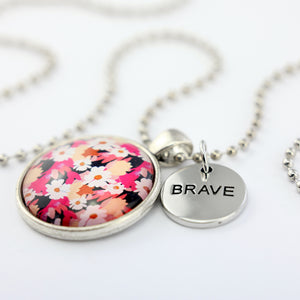 Circle pendant necklace in vintage silver with 'BRAVE' charm, bright pink floral print. Fundraiser for the national breast cancer foundation.