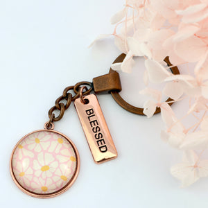 Circle pendant keychain in vintage copper with 'blessed' charm, floral print. Fundraiser for the national breast cancer foundation.