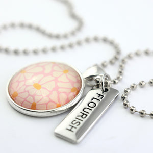 Circle pendant necklace in silver with 'flourish' charm, floral print. Fundraiser for the national breast cancer foundation.