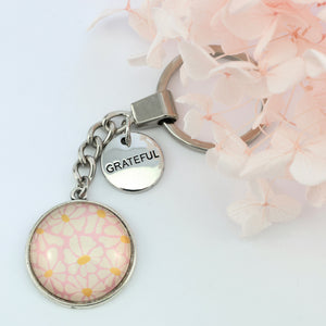 Circle pendant keychain in vintage silver with 'grateful' charm, floral print. Fundraiser for the national breast cancer foundation.