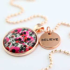 Pink print rose gold circle pendant necklace with ball chain and 'Believe' charm. This product is raising money for the National Breast Cancer Foundation. 