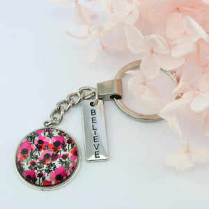 Pink print silver keychain circle pendant 'Believe' charm. This product is raising money for the National Breast Cancer Foundation. 