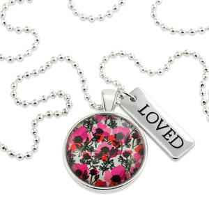 Pink print silver circle pendant necklace with ball chain and 'Loved' charm. This product is raising money for the National Breast Cancer Foundation. 