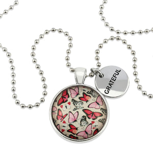 Pink floral print silver circle pendant necklace with ball chain with rose gold circle shape 'grateful' charm. Fundraising product for the National Breast Cancer Foundation. 