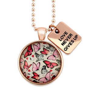 Pink floral print circle pendant rose gold necklace with ball chain with 'love never gives up' word charm. Fundraising product for the National Breast Cancer Foundation. 