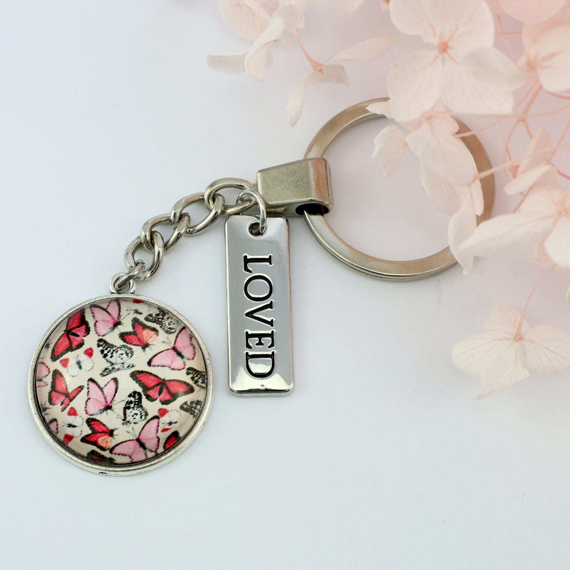 Pink floral print vintage silver circle pendant keychain with 'loved' charm. Fundraising product for the National Breast Cancer Foundation. 