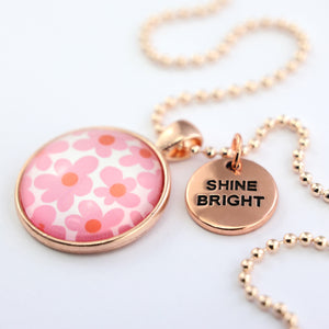 Pink floral print rose gold circle pendant necklace with 'shine bright' charm. A product that fundraises for the National Breast Cancer Foundation. 