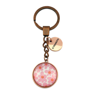 Pink floral print vintage red copper circle keychain with 'strength' charm. A product that fundraises for the National Breast Cancer Foundation. 