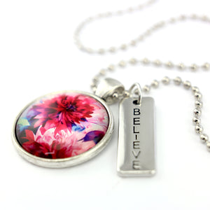 Pink floral print silver circle pendant necklace with 'believe' charm. A product that fundraises for the National Breast Cancer Foundation. 