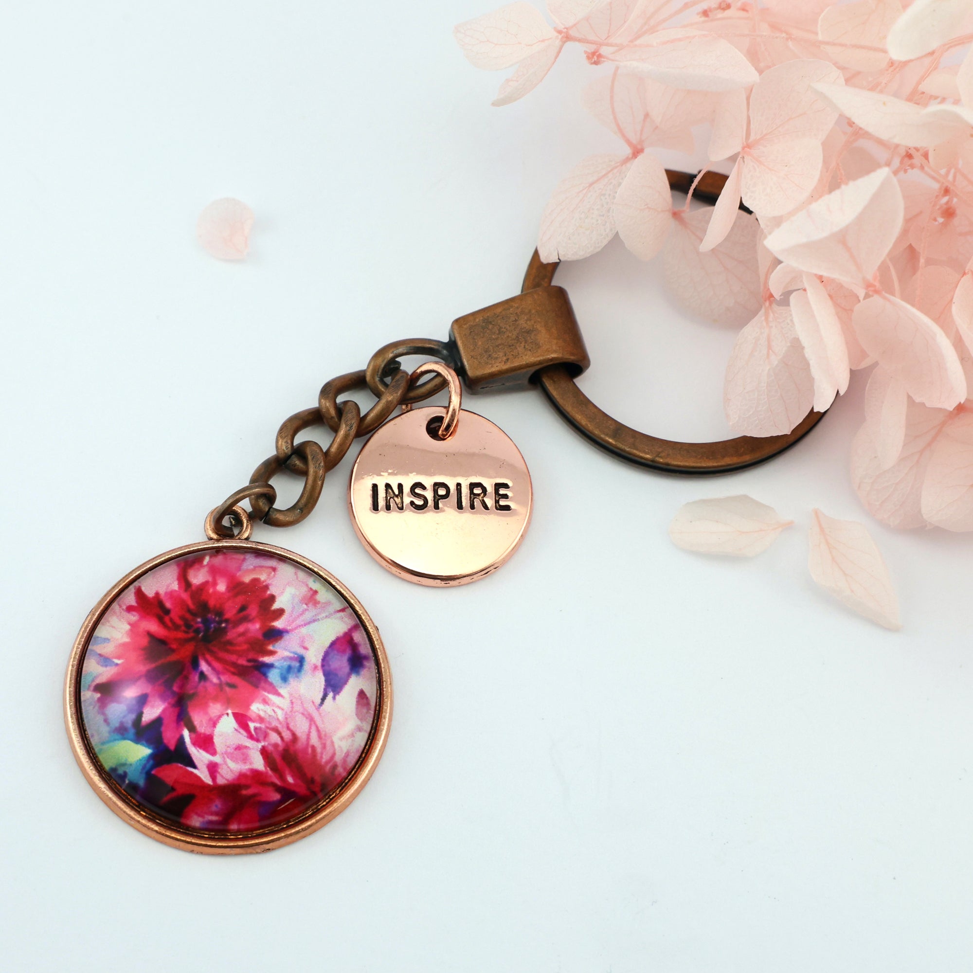 Pink floral print vintage copper circle pendant keychain with 'inspire' charm. A product that fundraises for the National Breast Cancer Foundation. 