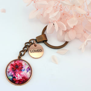 Pink floral print vintage copper circle pendant keychain with 'loved' charm. A product that fundraises for the National Breast Cancer Foundation. 