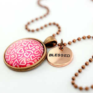 Pink heart print vintage red copper circle pendant necklace with 'blessed' charm. A fundraising product for the national breast cancer foundation. 