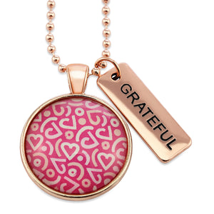 Pink heart print silver necklace circle pendant with grateful charm. A fundraising product for the national breast cancer foundation. 