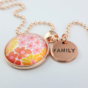 Pink floral print circle pendant silver ball chain necklace with rose gold 'family' word charm. Fundraising product for the National Breast Cancer Foundation. 