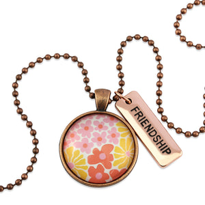 Pink floral print circle pendant vintage copper ball chain necklace with rose gold 'friendship' word charm. Fundraising product for the National Breast Cancer Foundation. 