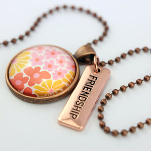 Pink floral print circle pendant vintage copper ball chain necklace with rose gold 'friendship' word charm. Fundraising product for the National Breast Cancer Foundation. 