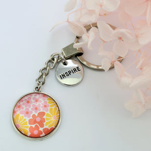 Pink floral print circle pendant vintage silver keychain with 'Inspire' word charm. Fundraising product for the National Breast Cancer Foundation. 