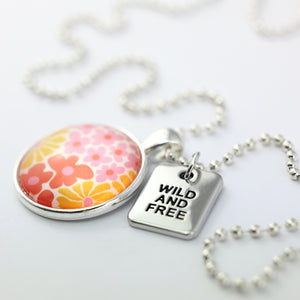 Pink floral print circle pendant silver ball chain necklace with SILVER 'wild and free' word charm. Fundraising product for the National Breast Cancer Foundation. 