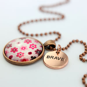 Pink floral print circle pendant vintage red copper ball chain necklace with rose gold 'brave' word charm. Fundraising product for the National Breast Cancer Foundation. 