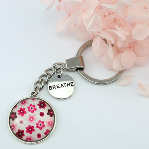 Pink floral print circle keychain pendant silver 'warrior' word charm. Fundraising product for the National Breast Cancer Foundation. 