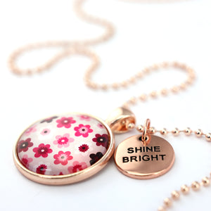 Pink floral print circle pendant rose gold ball chain necklace with rose gold 'shine bright' word charm. Fundraising product for the National Breast Cancer Foundation. 