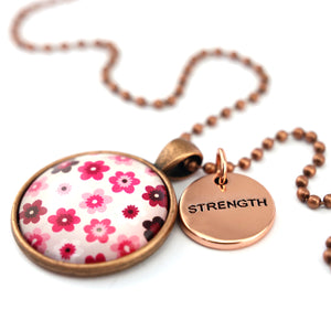 Pink floral print circle pendant vintage red copper ball chain necklace with rose gold 'strength' word charm. Fundraising product for the National Breast Cancer Foundation. 