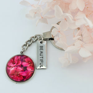 Circle pendant keyring in vintage silver with 'brave' charm, floral print. Fundraiser for the national breast cancer foundation.