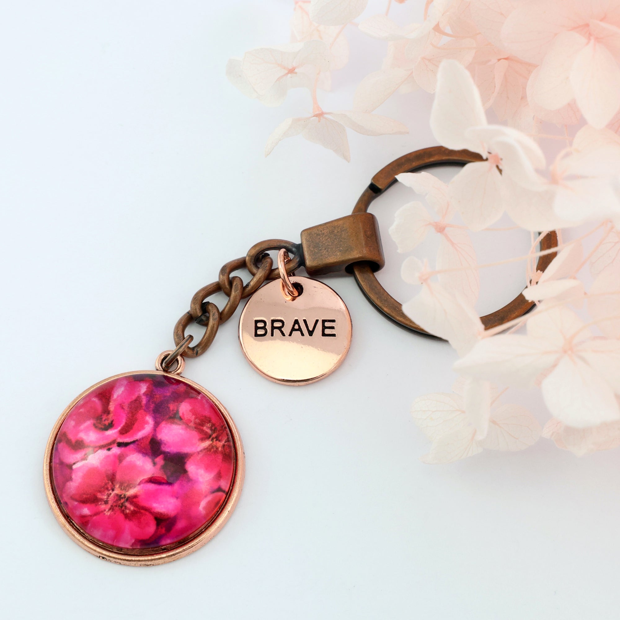 Circle pendant keyring in vintage red copper with rose gold 'brave' charm, floral print. Fundraiser for the national breast cancer foundation.