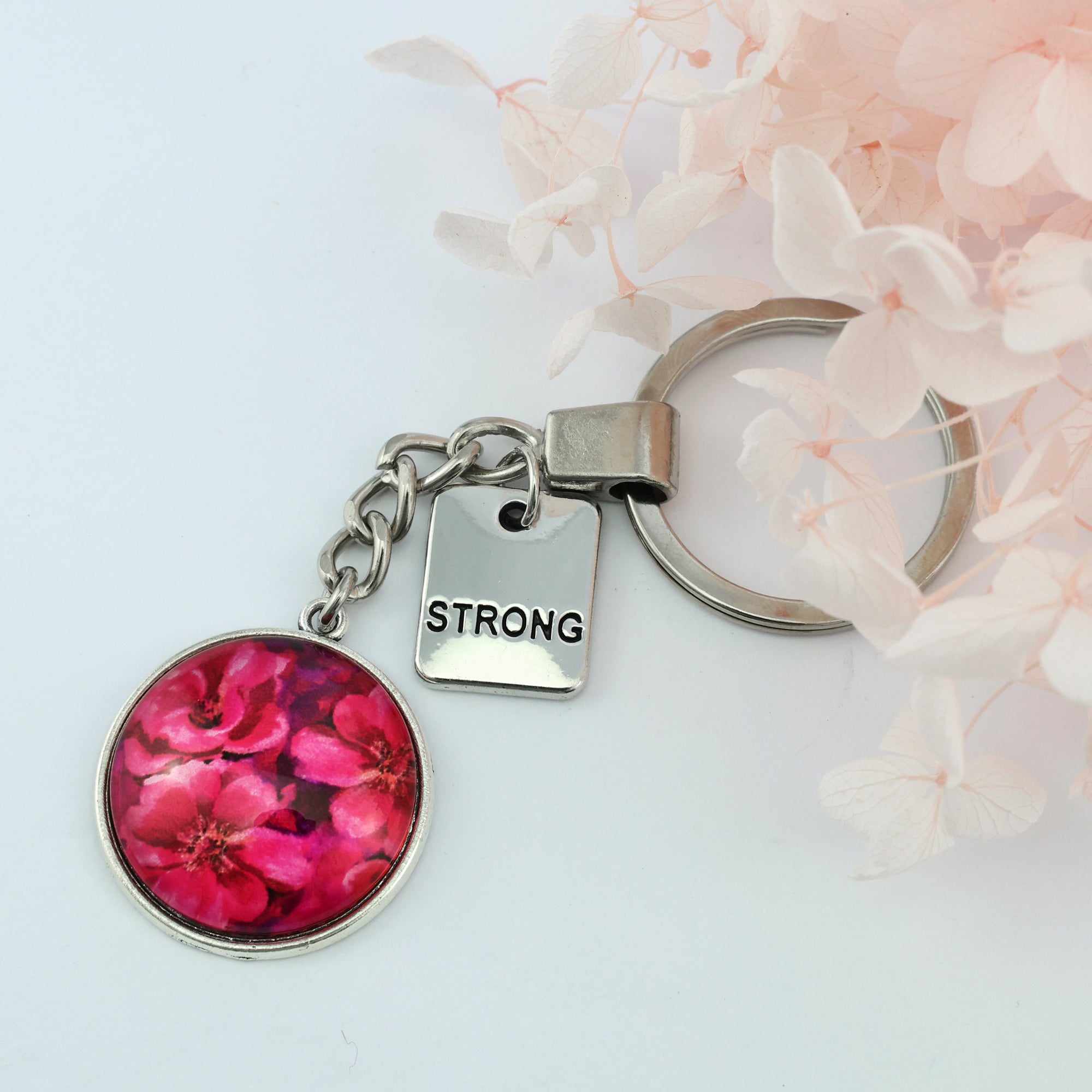 Circle pendant keyring in vintage silver with 'strong' charm, floral print. Fundraiser for the national breast cancer foundation.