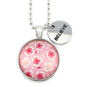 Pink floral print circle pendant silver ball chain necklace with silver 'believe' word charm. Fundraising product for the National Breast Cancer Foundation. 