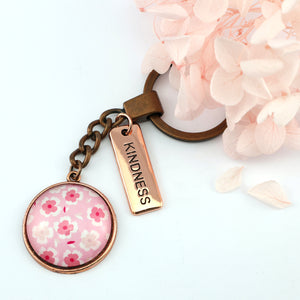 Circle pendant keyring in vintage copper with 'kindness' charm, soft pink floral print. Fundraiser for the national breast cancer foundation.