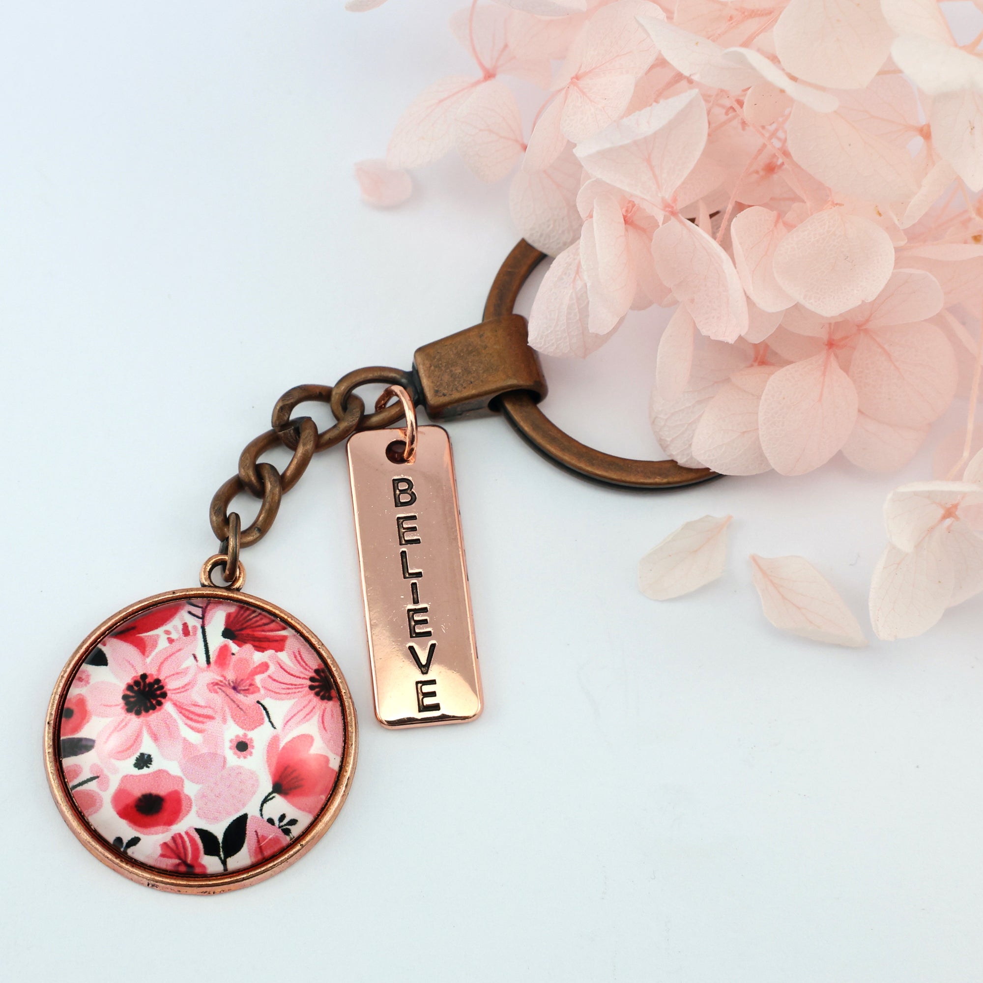 Circle pendant keyring in vintage copper with 'believe ' charm, pop pink floral print. Fundraiser for the national breast cancer foundation.