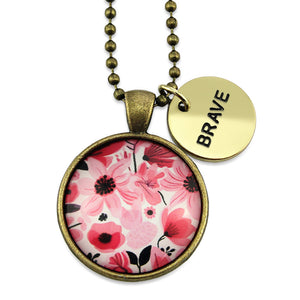 Pink floral print circle pendant vintage gold ball chain necklace with gold 'brave' word charm. Fundraising product for the National Breast Cancer Foundation. 