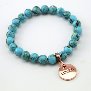 Teal coloured stone bracelet with word charm and rose gold clip. 